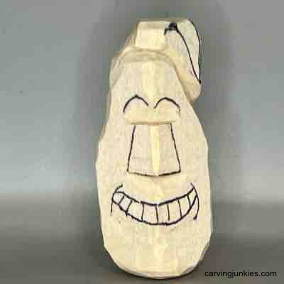 Nose and eyebrows are sketched on wood carved pear caricature
