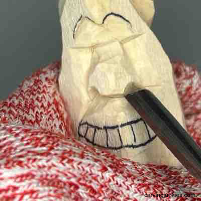 Carving nostrils on wood carved pear caricature