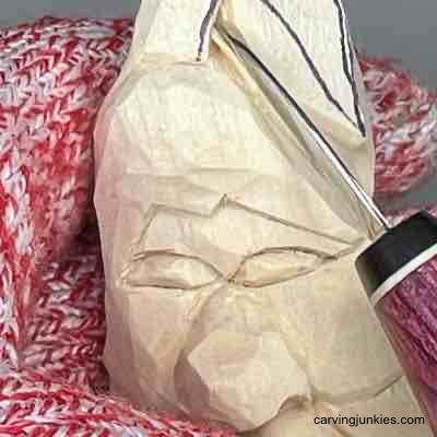 Carving the stem on a wood carved pear caricature