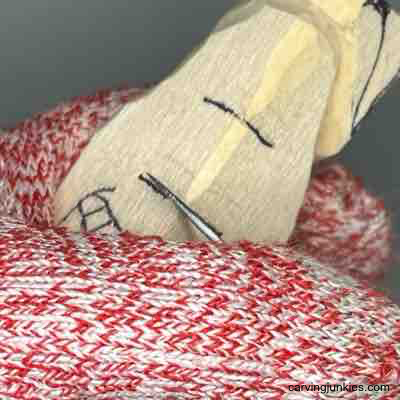 Making a stop cut on nose of wooden pear caricature