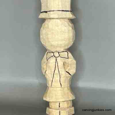 Details are added to wood carved scarecrow