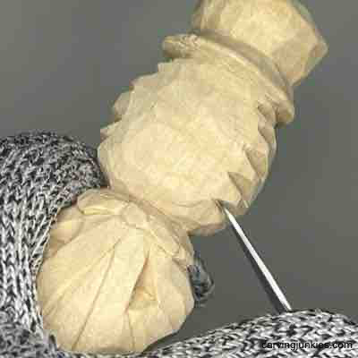 Making V-cuts to carve straw hair on wood carved scarecrow