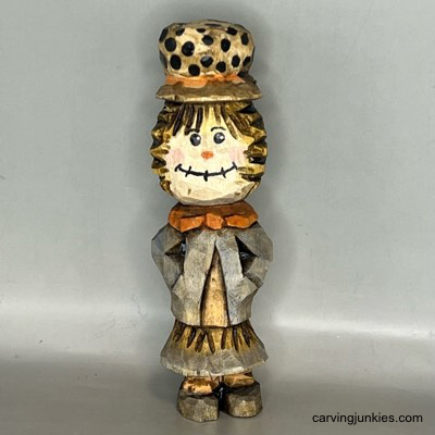 Front view of painted wood carved scarecrow