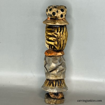 Left view of painted wood carved scarecrow