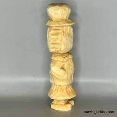 Right view of unpainted wooden scarecrow carving