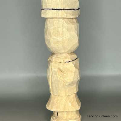 Scarf is sketched on wood carved scarecrow