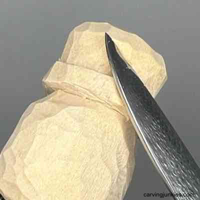 Shaping hat on wood carved scarecrow