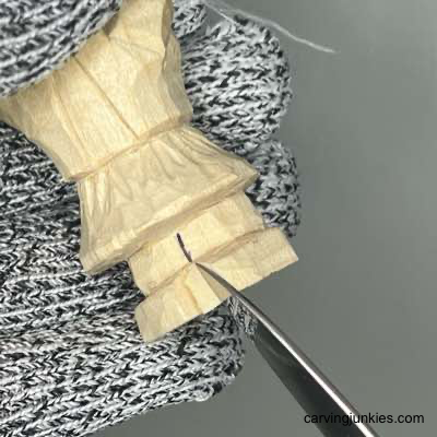 Splitting shoes with knife on wood carved scarecrow