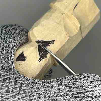 Making a stop cut on wood carved scarecrow