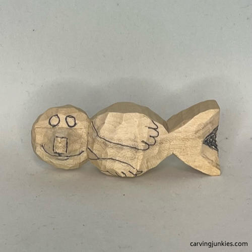 Facial details sketched on wood carved seal