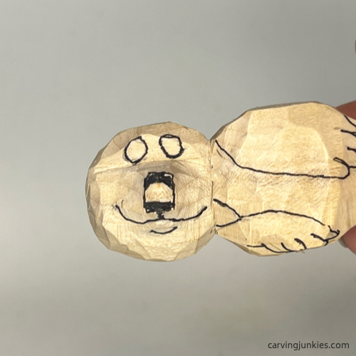 Wood is marked for removal on snout of wood carved seal