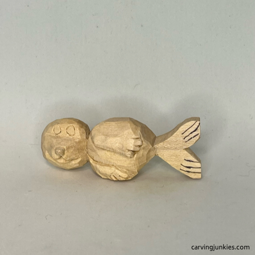 Marking lines on tail of wood carved seal