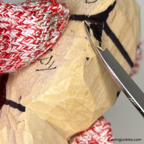 Using a V-cut to remove wood on wood carved seal
