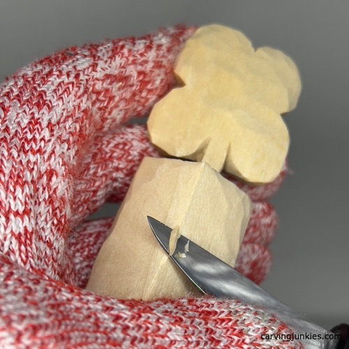 Shaping bucket with a knife while carving a four-leaf clover