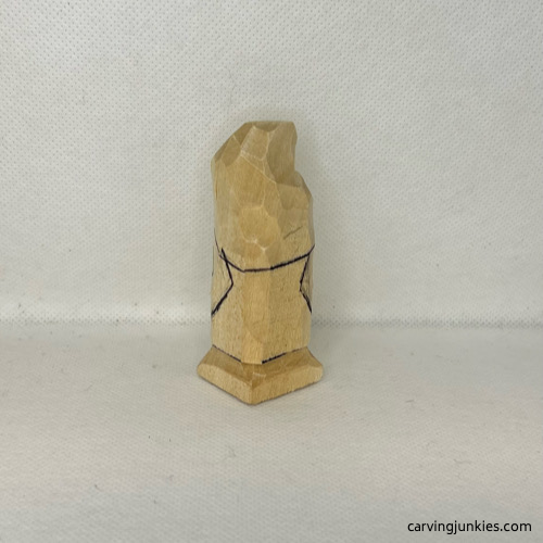 Back guidelines are drawn on wood carved valentine gnome