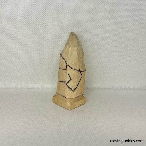 Left guidelines are drawn on wood carved valentine gnome