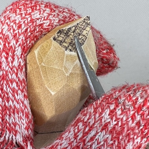 Narrowing point on top of wood carved valentine gnome hat