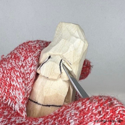 Shaping cheeks on wood carved Valentine gnome