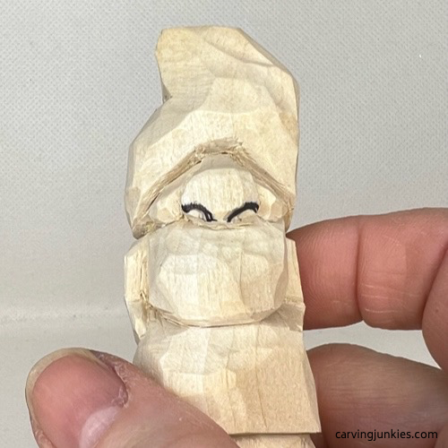 Curved nostrils are drawn on wood carved valentine gnome