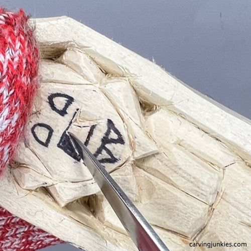 Making second pyramid cut on wood carved vampire