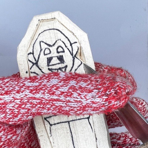 Making pyramid cut on wood carved vampire