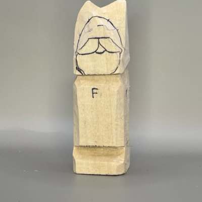 Facial details are sketched on wood carved Viking