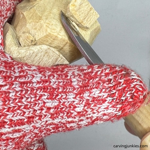 Shaping paws on wooden dog carving