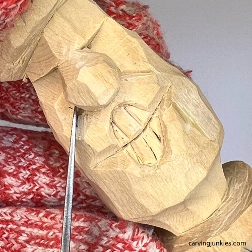 Carving smile lines on wooden mushroom carving