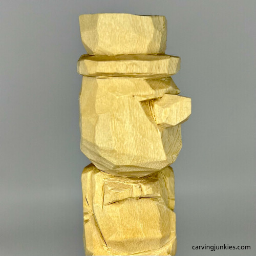 Cut nose on little man caricature carving