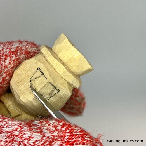 Making stop cut under nose on little man caricature carving