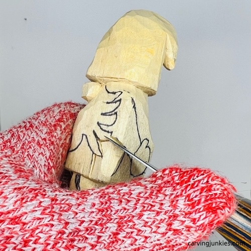 Carving arms on wooden gnome