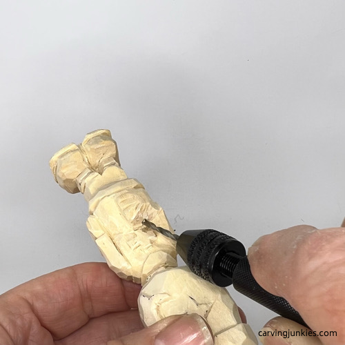 Using hand drill to make hold in wooden hand