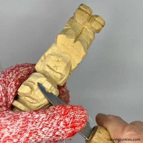 Shaping cheeks on little man caricature carving