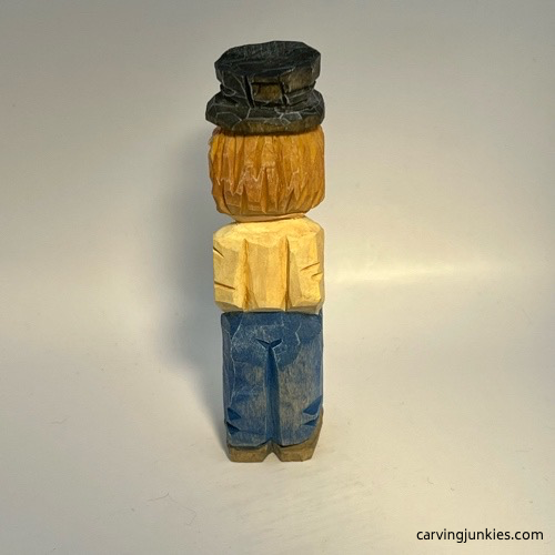 Back view of painted little man caricature carving