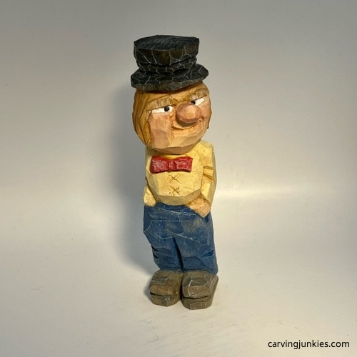 Front view of painted little man caricature carving