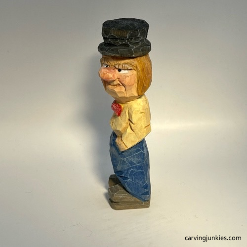Left view of painted little man caricature carving