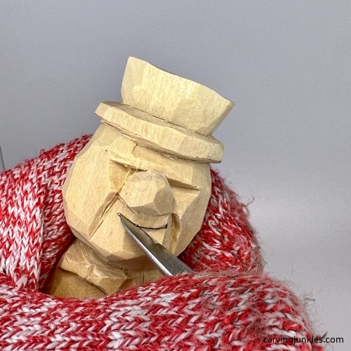 Carving smile on little man caricature carving